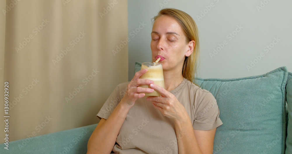 Woman Enjoying Iced Coffee on a Cozy Couch Woman Enjoying Iced Coffee on a Cozy Couch
