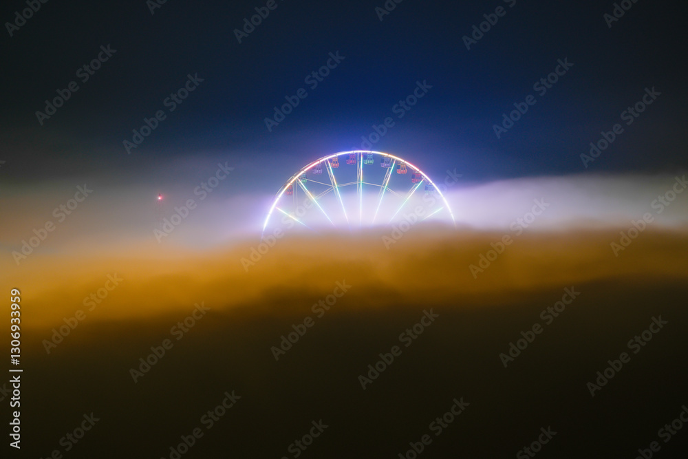 Fototapeta premium Diabelski młyn wśród mgły – tajemniczy nocny krajobraz 