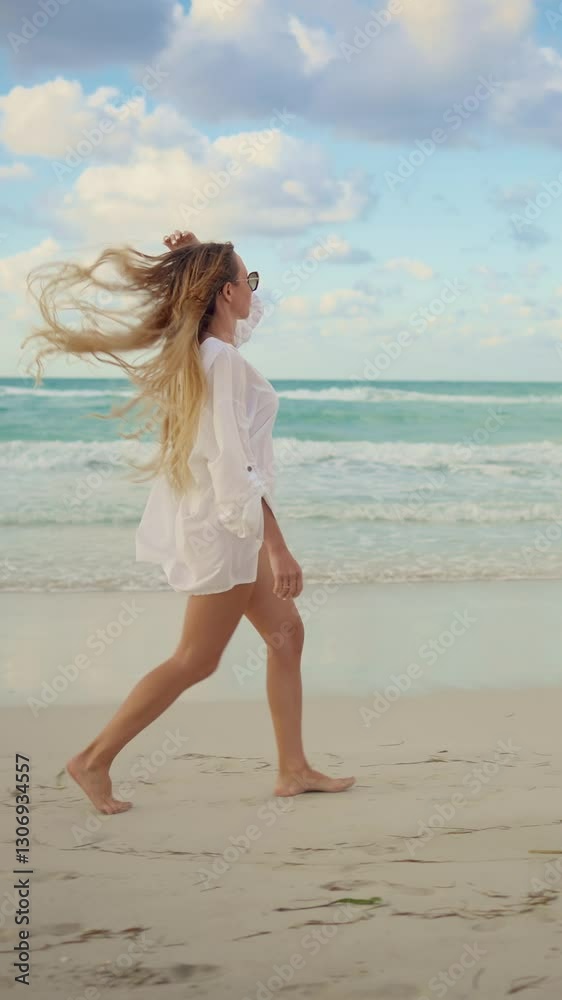 Happy woman on oceanic shore, side view of slender female vacationer walking on coast. Breathtaking seascape in horizon, slow motion vertical video, traveling and tourism in summer vacation, good mood Happy woman on oceanic shore, side view of slender female vacationer walking on coast. Breathtaking seascape in horizon, slow motion vertical video, traveling and tourism in summer vacation, good mood