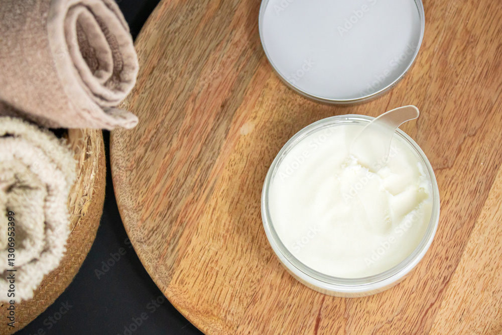 A jar of cream on a wooden tray, emphasizing natural ingredients, skincare, spa, and relaxation. A jar of cream on a wooden tray, emphasizing natural ingredients, skincare, spa, and relaxation.