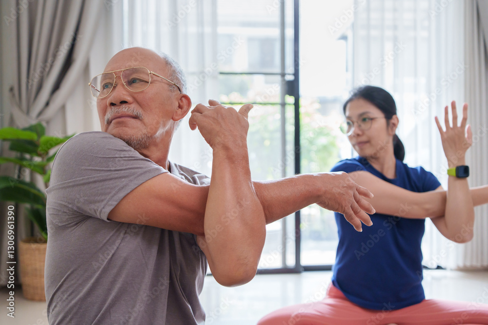 Obraz premium Asian senior man and young woman engage in stretching exercises in their living room. Focusing on maintaining flexibility and strength while enjoying quality time together.