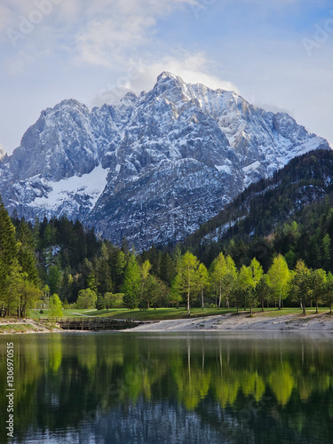 Julian alps casting perfect reflection on glassy jasna lake waters, showcasing serene mountain landscape in triglav national park, slovenia