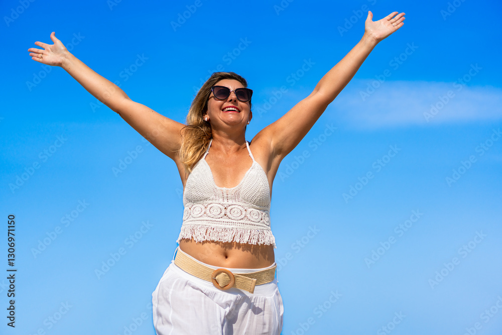 Portrait of beautiful middle-aged woman enjoying life standing against blue sky background. Happiness and freedom Portrait of beautiful middle-aged woman enjoying life standing against blue sky background. Happiness and freedom