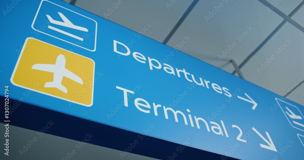 Close Up of Big Navigation Sign Hanging on Ceiling Directing Passengers to Departures, Terminals And Gates for Boarding Airplane Flight. Navigation Sign in Busy Modern International Airport Terminal. Close Up of Big Navigation Sign Hanging on Ceiling Directing Passengers to Departures, Terminals And Gates for Boarding Airplane Flight. Navigation Sign in Busy Modern International Airport Terminal.