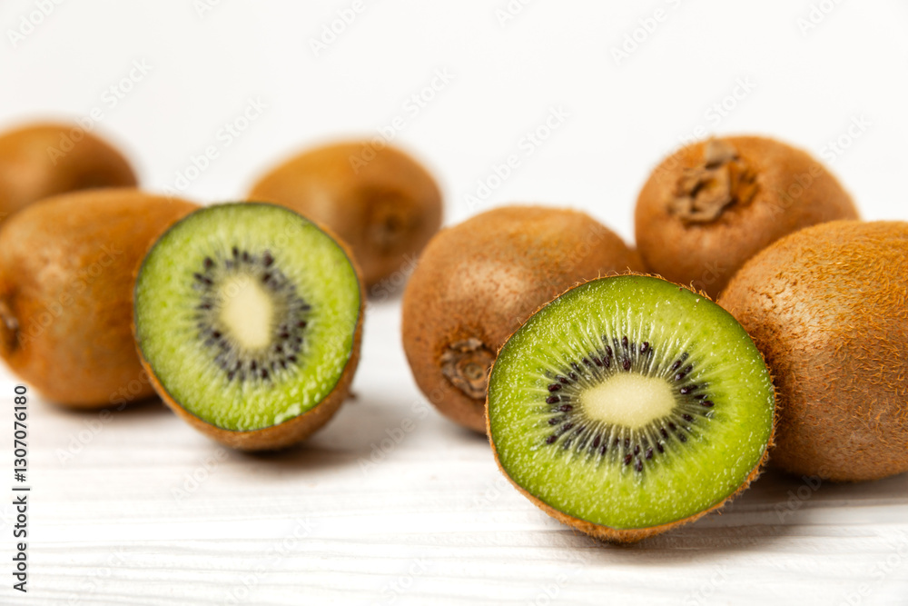 Fototapeta premium Kiwi on wooden background. Whole fruit and slices pieces of green kiwi on table. fresh ripe juicy kiwi. Tropical fruit. Organic fruit. Healthy eating. Space for text. Copy space.