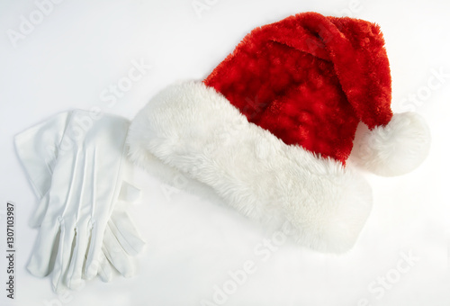 A santa hat with gloves on a white background, ready for Christmas.