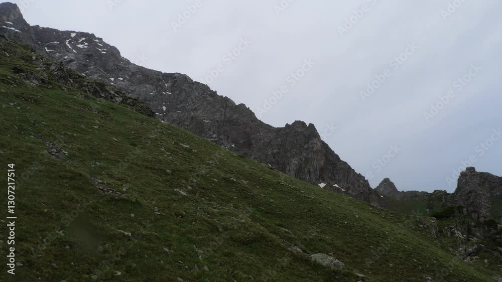 A mountain peak blanketed in green grass. Climbing high into the mountains. Wildlife. Mountain recreation A mountain peak blanketed in green grass. Climbing high into the mountains. Wildlife. Mountain recreation
