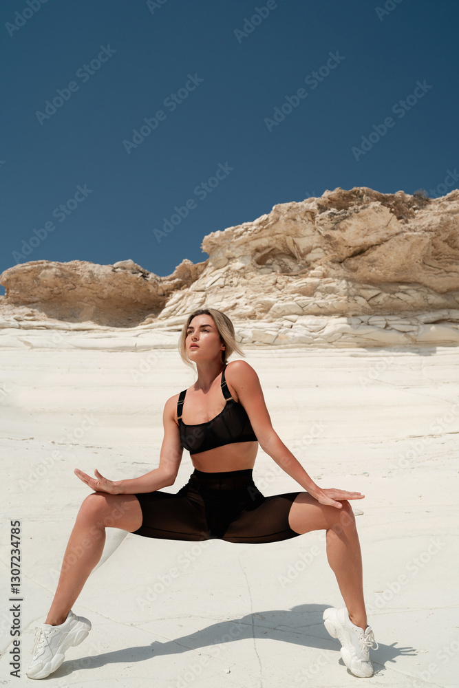 Confident Woman in Sheer Black Activewear Posing on White Sandstone