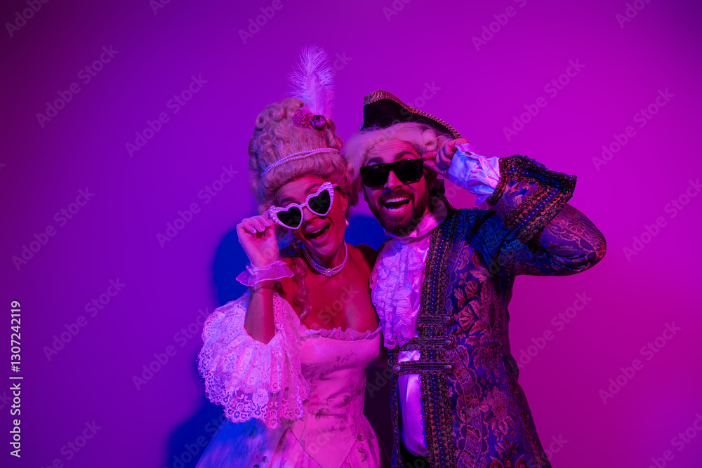 Fototapeta premium Two elegantly dressed individuals posing in vintage costumes under neon lights reflecting a lively party atmosphere
