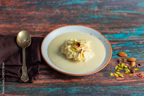 Rabdi is a rich, creamy Indian dessert made by slow-cooking milk until thick, then sweetened with sugar, flavored with cardamom, and garnished with nuts. photo