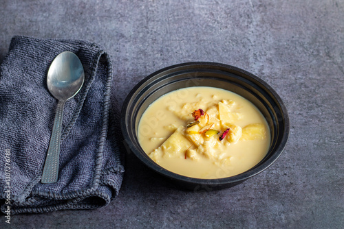 Rabdi is a rich, creamy Indian dessert made by slow-cooking milk until thick, then sweetened with sugar, flavored with cardamom, and garnished with nuts. photo