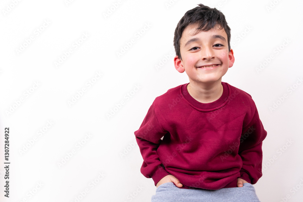 Smiling boy in red sweater and gray pants on isolated white background. Happy child. Happiness, youth, and simplicity concept Smiling boy in red sweater and gray pants on isolated white background. Happy child. Happiness, youth, and simplicity concept