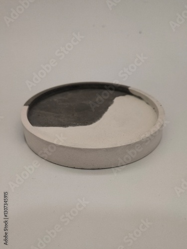 A handcrafted cylindrical concrete planter with a black and white artistic pattern, ideal for modern home decoration.