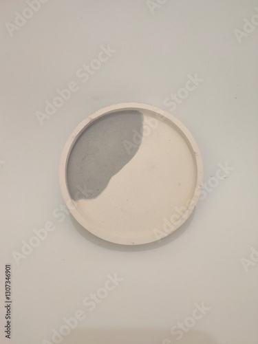 A minimalist round concrete tray with a monochrome design, featuring a smooth finish. Ideal for home decor or storage purposes.