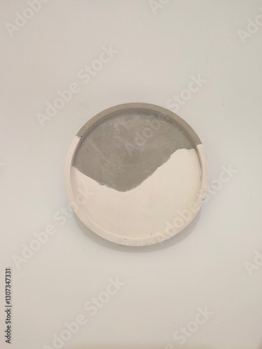 Round concrete plant saucer with a modern white and gray pattern on a plain background.