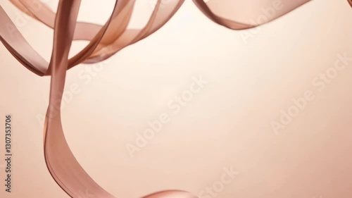 Subtle orbit video of a cascade of soft blush pink and ivory ribbons falling through a softly blurred, light peach background, natural window light