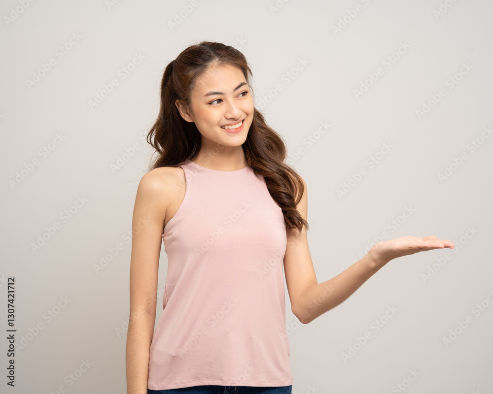 Beautiful happy young asian woman age around 25 pointing finger hands palm up. Charming female lady standing pose on isolated white background. Asian woman people in pink shirt Beautiful happy young asian woman age around 25 pointing finger hands palm up. Charming female lady standing pose on isolated white background. Asian woman people in pink shirt