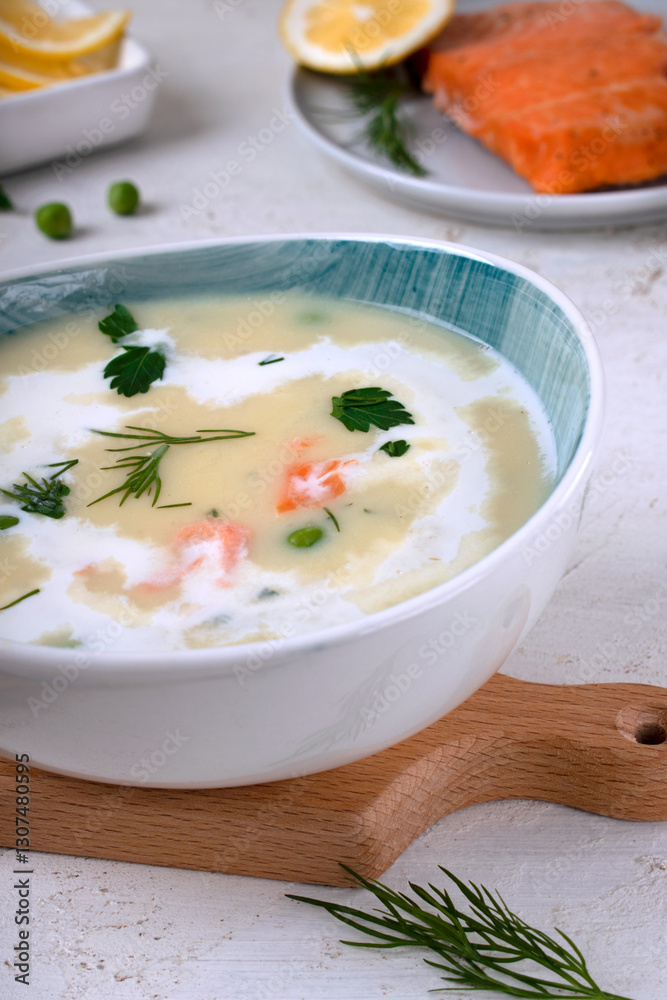 Cream soup with smoked trout, green peas and cream, served in a ceramic bowl. Hot comfort food Cream soup with smoked trout, green peas and cream, served in a ceramic bowl. Hot comfort food