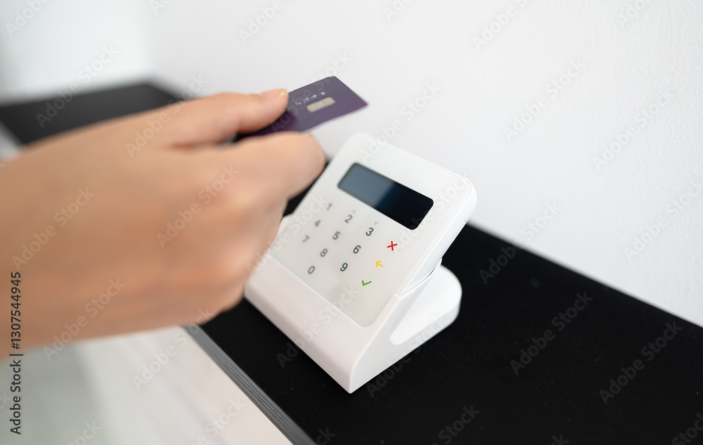 Woman's hand making a contactless payment with a card on a wireless terminal. Woman's hand making a contactless payment with a card on a wireless terminal.