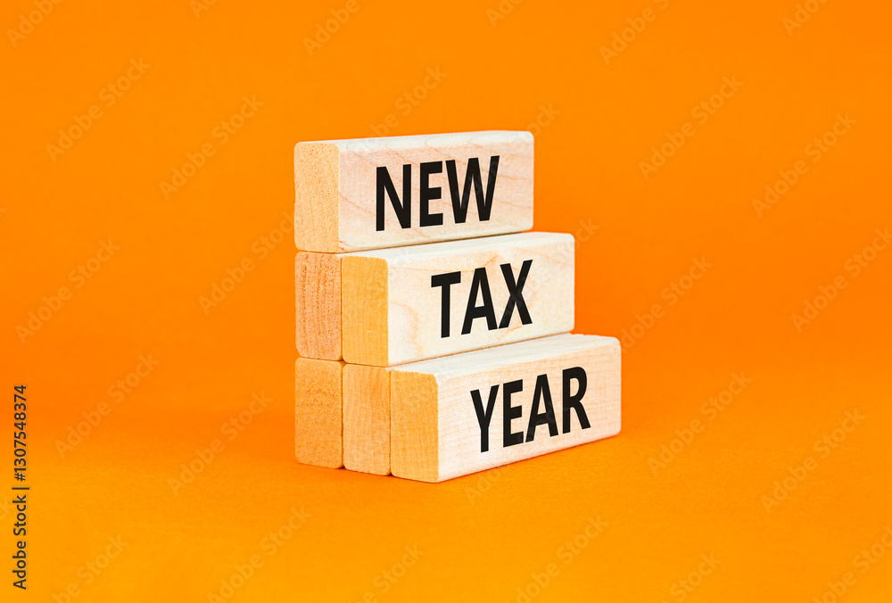 Naklejka premium New tax year symbol. Concept words New tax year on beautiful wooden blocks. Beautiful orange table orange background. Business new tax year concept. Copy space.