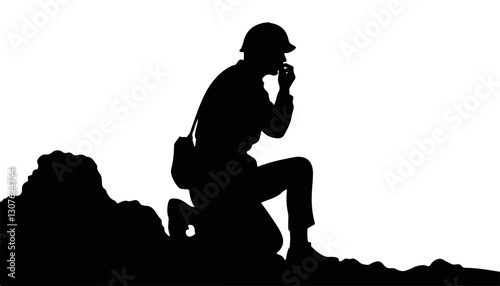Silhouette of soldier kneeling in contemplation on rocky terrain