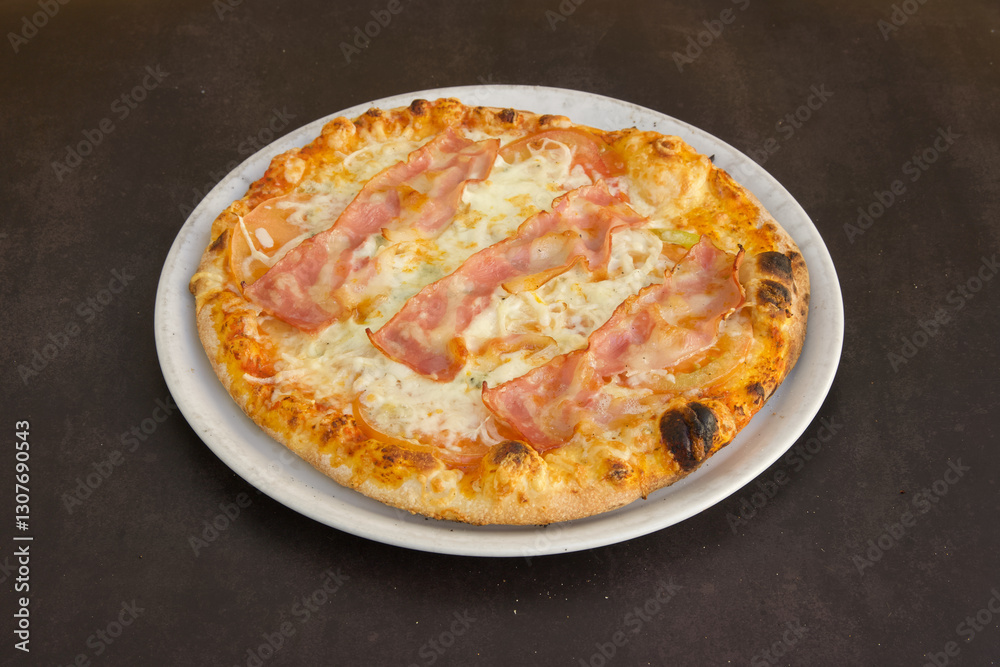 A pizza with ham and cheese on a white plate A pizza with ham and cheese on a white plate