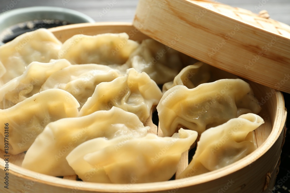 Tasty boiled gyoza (dumplings) in bamboo steamer on table, closeup Tasty boiled gyoza (dumplings) in bamboo steamer on table, closeup