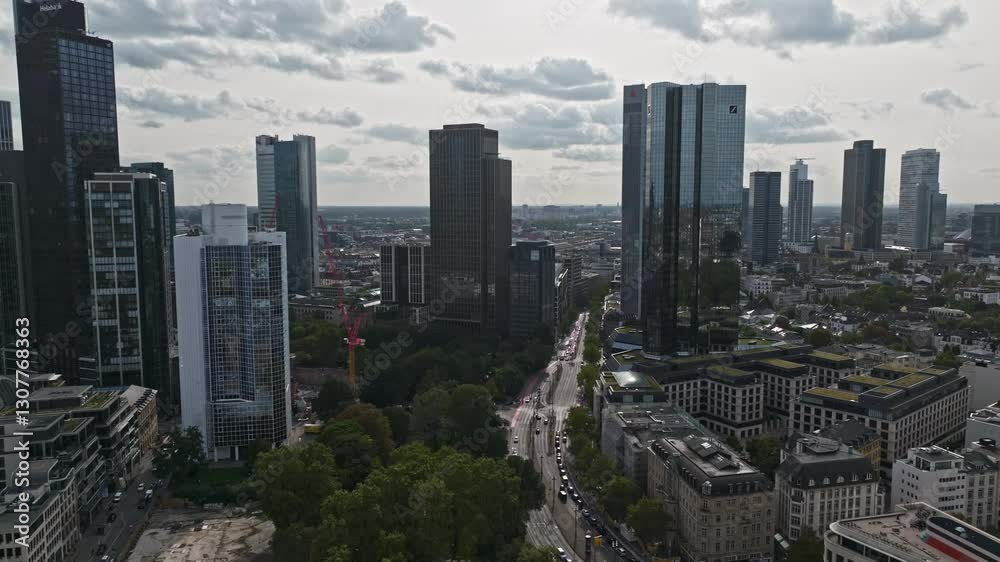 Aerial drone view of Gallusanlage, a peaceful green space near Willy-Brandt-Platz in Frankfurt, surrounded by skyscrapers and featuring shade trees, sculptures, a monument, and a WWI memorial. Aerial drone view of Gallusanlage, a peaceful green space near Willy-Brandt-Platz in Frankfurt, surrounded by skyscrapers and featuring shade trees, sculptures, a monument, and a WWI memorial.