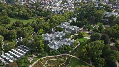 Aerial drone view of Palmengarten, Frankfurt, Germany, showcasing the vast botanical garden with lush greenery, exotic plants, walking paths, and scenic landscapes. 