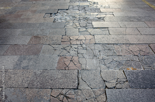 Obraz na płótnie The fractured, uneven ground of a weathered pavement at an urban sidewalk or ped