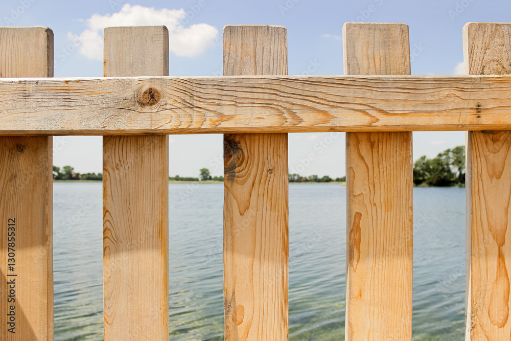 Obraz premium Light Wooden Fence with Lake View in Summer Nature Landscape