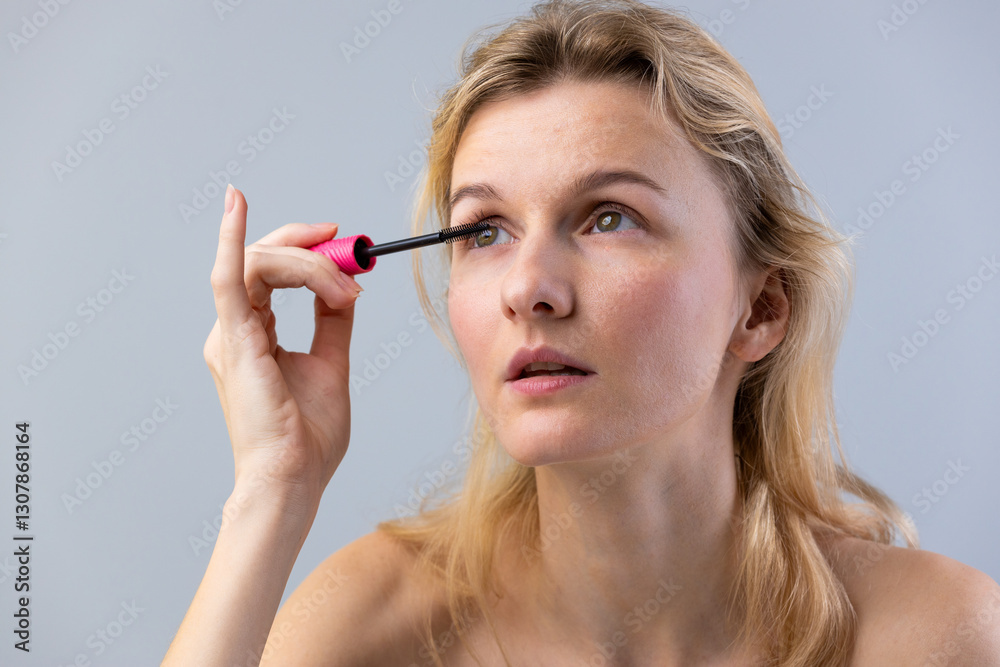 Woman Applying Mascara with Confidence: Embracing Beauty and Self-Expression Through Makeup in a Soft Lighting Environment Woman Applying Mascara with Confidence: Embracing Beauty and Self-Expression Through Makeup in a Soft Lighting Environment