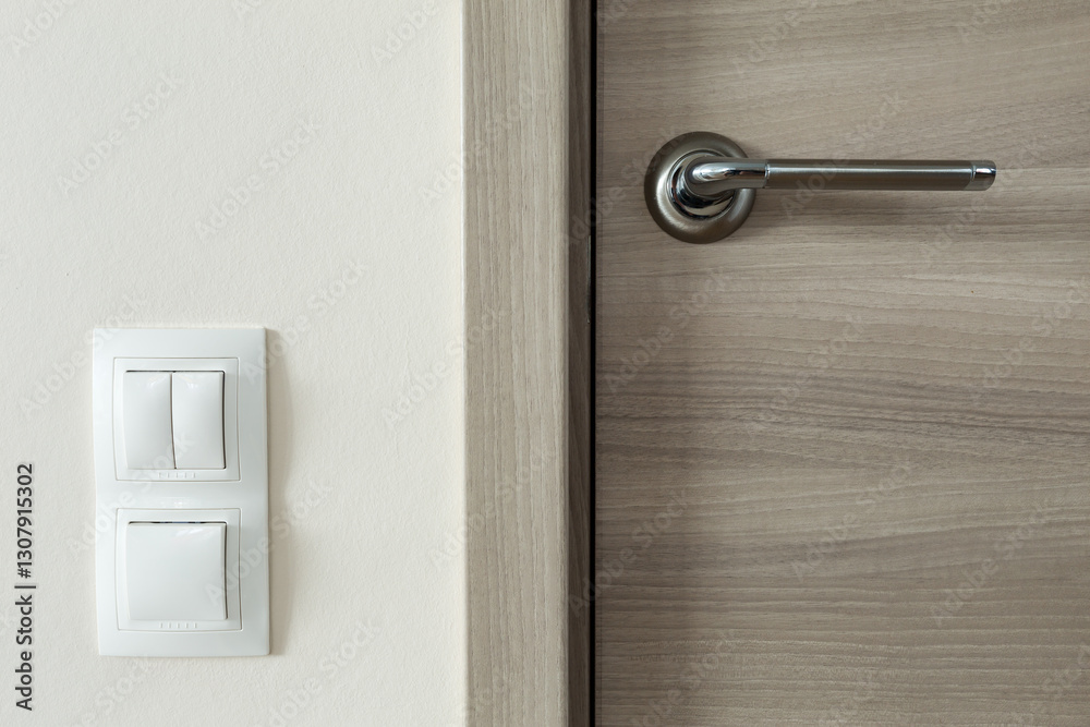 Door handle and white lighting switches on wall Door handle and white lighting switches on wall