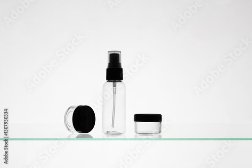 Empty cosmetic products on a glass shelf. Mockup transparent bottles of different sizes for advertising on white background photo