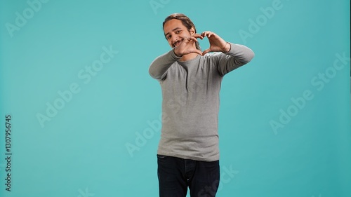 Φωτογραφία Portrait of joyful friendly man doing heart symbol shape gesture with hands