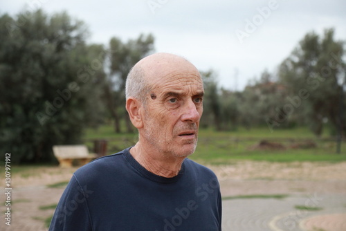Elderly Man Waits For The Bus Impatiently At The Bus Stop In The Countryside