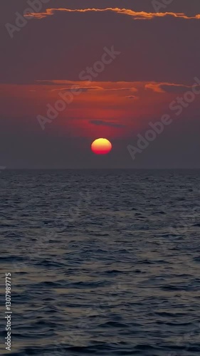 A breathtaking view of the sun setting over the ocean, casting warm orange and purple hues across the sky. Ideal for relaxation, travel, and nature themes.