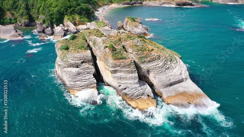 Rugged cliffs by turquoise waters, waves crashing on rocks, patches of greenery adding contrast and a nearby beach area, blending natural beauty, lively charm. Sardalya Bay, Kandıra, Kocaeli, Turkey 
