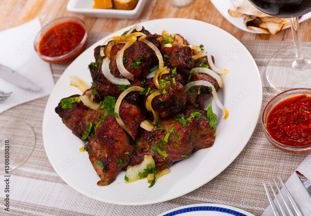 Popular russian dish shashlik, barbecued pork meat served with onion and herbs Popular russian dish shashlik, barbecued pork meat served with onion and herbs