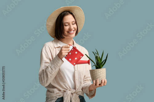 Happy young woman watering ...