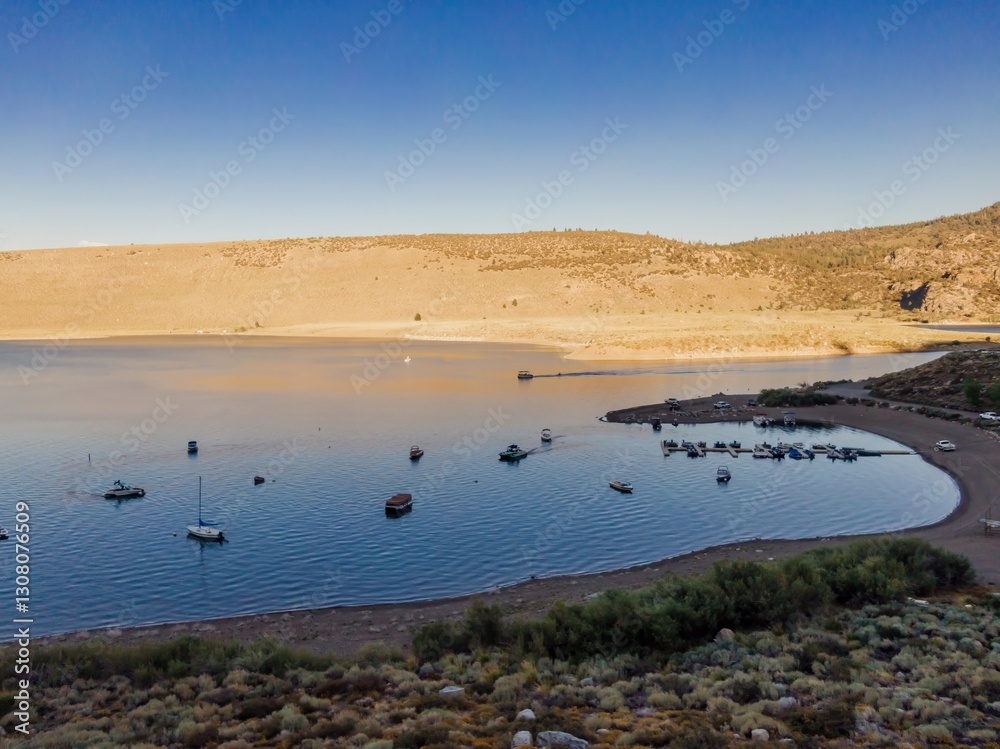 Scenic view of a marina with boats docked on Grant Lake, surrounded by mountains and desert vegetation in California, USA. Recreational boating. une Lake, California, USA Scenic view of a marina with boats docked on Grant Lake, surrounded by mountains and desert vegetation in California, USA. Recreational boating. une Lake, California, USA