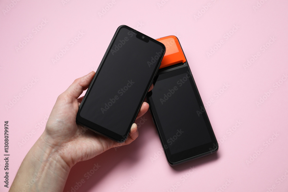 Woman with smartphone using payment terminal on pink background, top view Woman with smartphone using payment terminal on pink background, top view