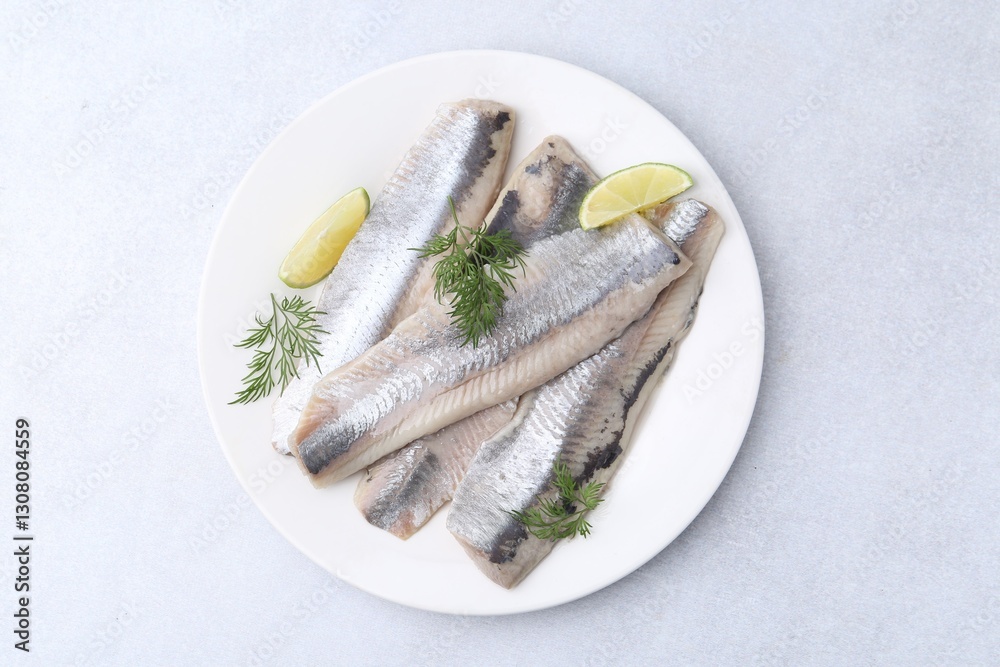 Marinated herring fillets with lime and dill on grey table, top view Marinated herring fillets with lime and dill on grey table, top view