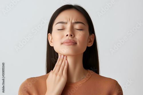 Asian girl with neck pain. Concept of sore throat, pharyngitis, laryngitis, thyroiditis, choking photo