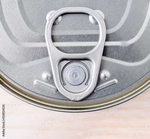 A close-up top-down view of a round tin can of tuna