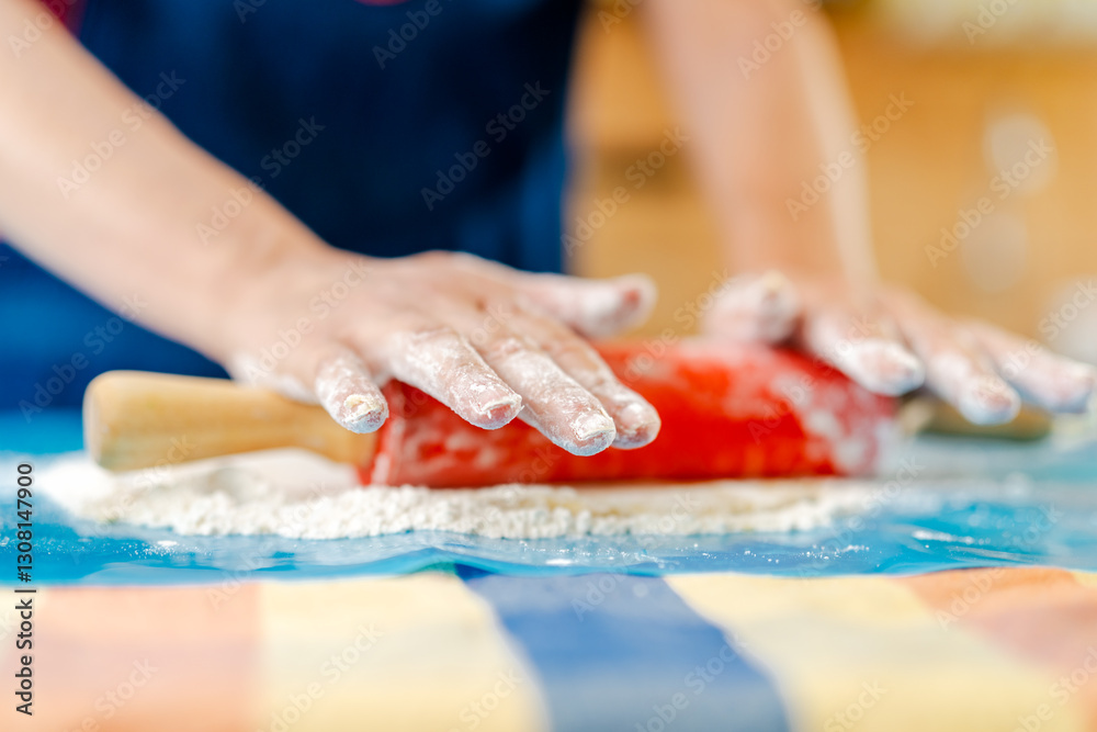 Obraz premium Chef using rolling pin, preparing dough on floured surface
