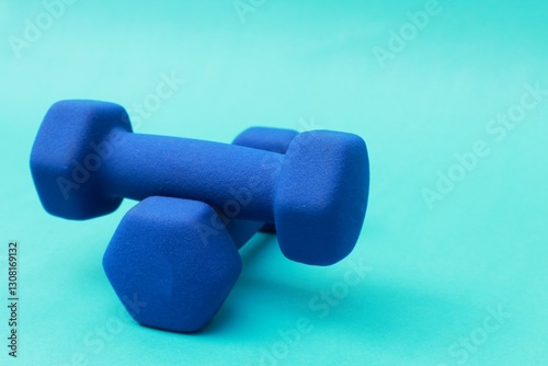 Two blue barbells stacked on a blue background