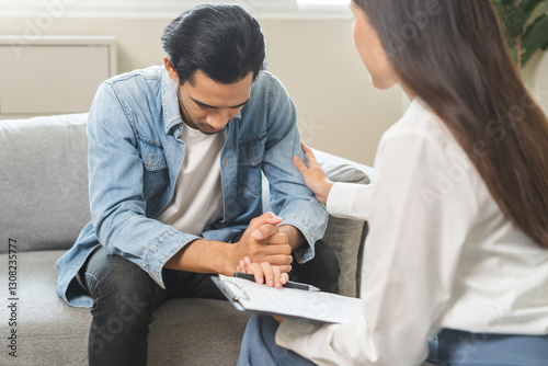 Psychology, depression. Sad asian young man consulting with psychiatrist while patient counseling mental therapy problem with doctor at clinic. Psychologist encouraging with sick mental health person.