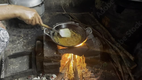 Chef is holding spatula or wok and stirring or cooking with fire or flames