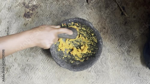Footage of human hands are grinding spices in a mortar to make cooking spices